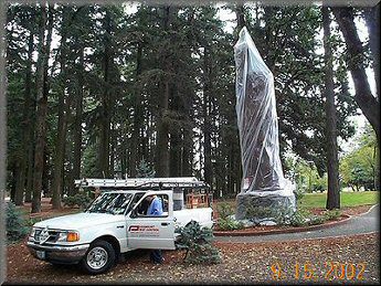 A white truck parked in front of a statue.
